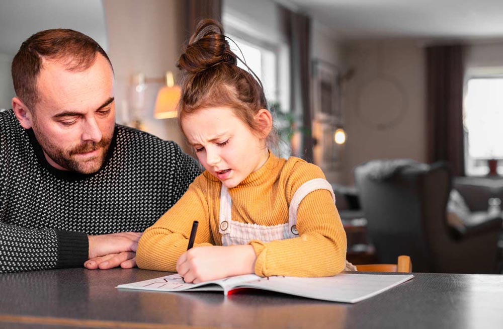 Pappa hjälper dotter med hennes läxor